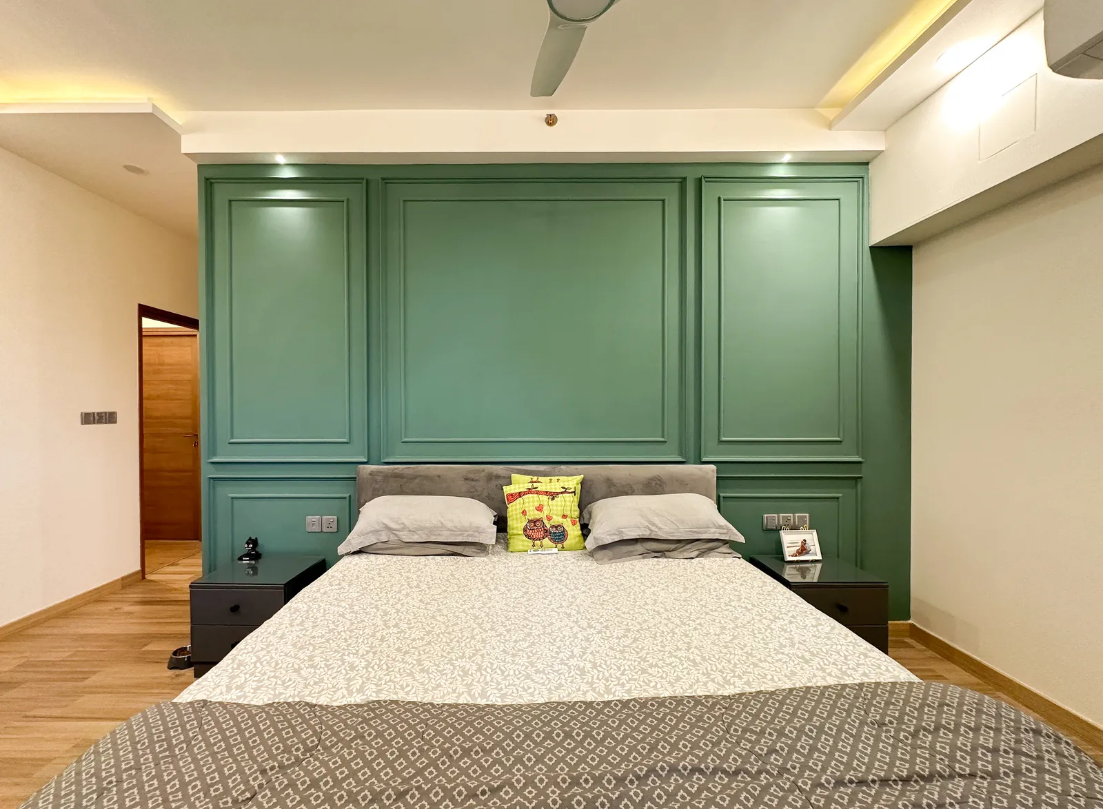 Bedroom with sage-green panelled headboard wall — Somani's Residence